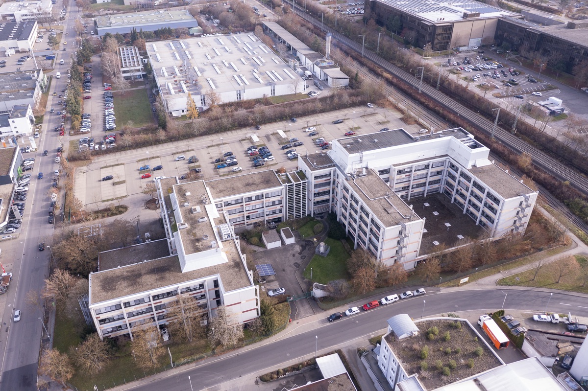 Bürocampus aus der Luft, mehrere Gebäude und Parkplätze im Winter