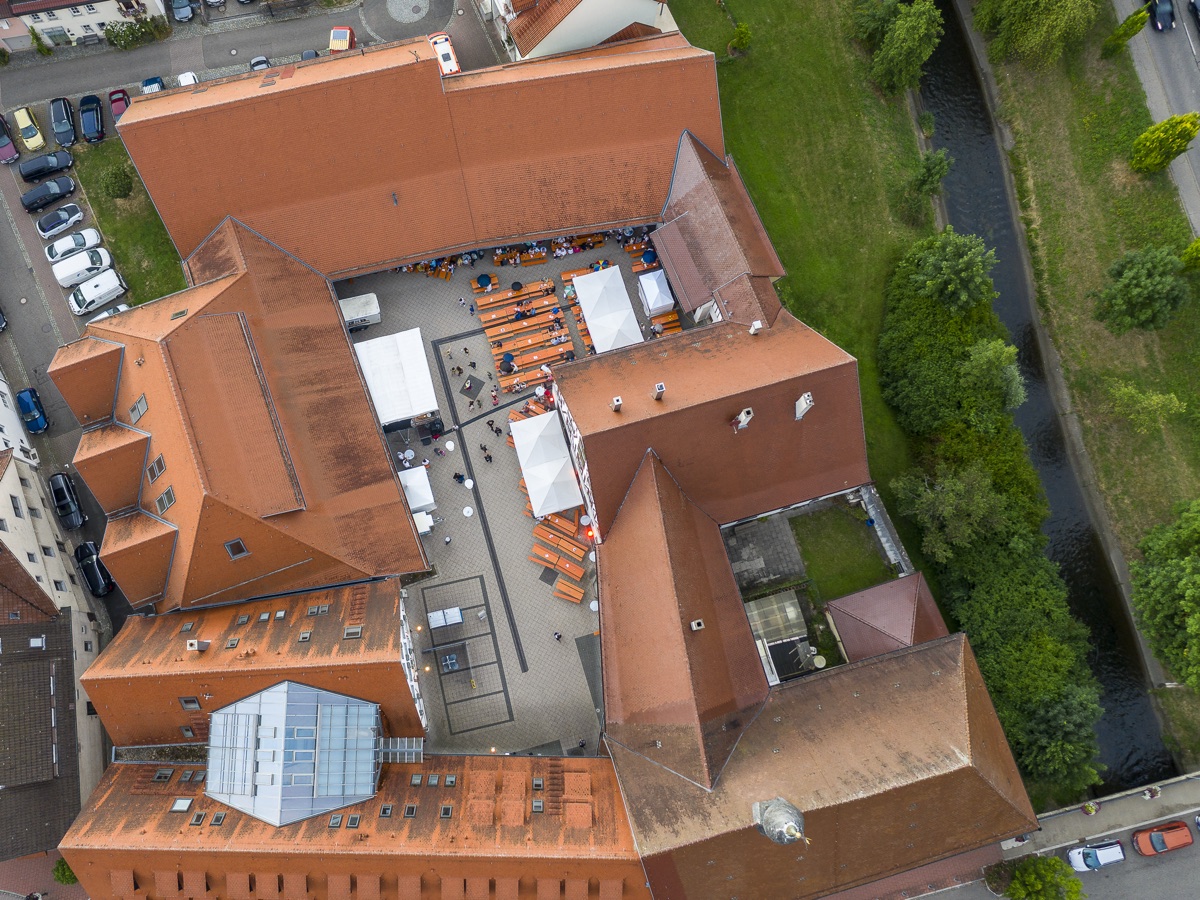 Luftaufnahme: Innenhofbestuhlung eines Straßenfests in der Altstadt