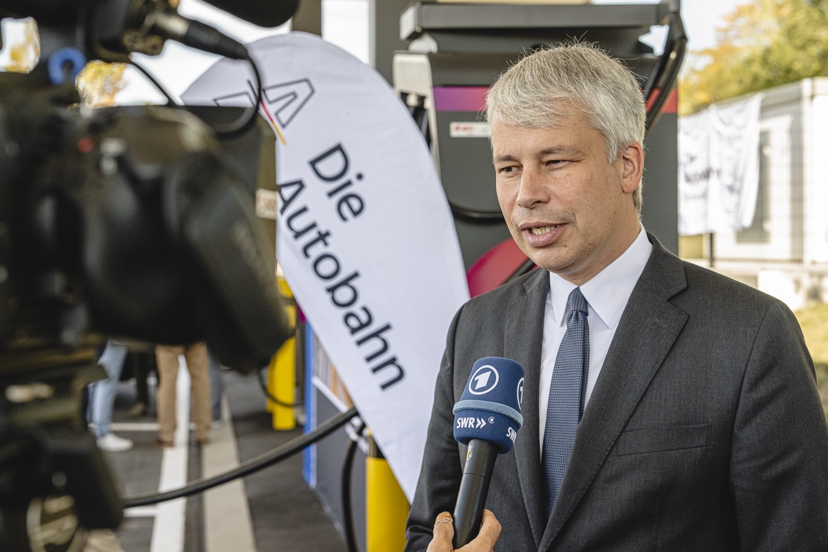 Fernsehinterview mit Mikrofon vor der Ladesäule